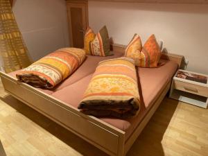 una cama con almohadas encima en una habitación en Ferienhäuser Geiersberg, en Hauzenberg