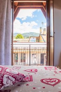 a bedroom with a bed with a view of a balcony at Albergo alla Posta B&B in Roana