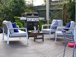 a patio with three chairs and a grill and a table at number41 Bed + Breakfast in Blenheim