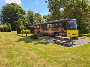 a bus parked in a park with a picnic table at Baie de Somme Bus in Saint-Blimont
