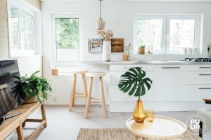 een keuken met witte kasten en een tafel en stoelen bij nummer 100 - 2 in Leeuwarden