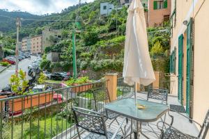 una mesa con una sombrilla en un balcón en il giardino di Riomaggiore, en Riomaggiore
