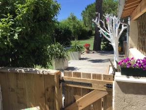 een tuin met een houten hek en bloemen bij Le mas des mourguettes in Saintes-Maries-de-la-Mer