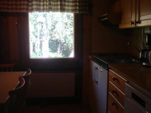 cocina con ventana, fregadero y encimera en Hakamajat Cottages, en Syöte