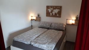 a small bedroom with a bed and two lights at Kleine Auszeit in Möhnesee