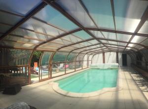 a large swimming pool with a glass ceiling at Les sentiers du lac in Sorèze