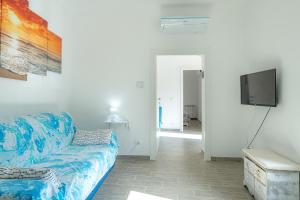 Una sala de estar con un sofá azul y un televisor de pantalla plana. en il giardino di Riomaggiore, en Riomaggiore
