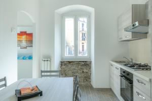 cocina blanca con mesa y ventana en il giardino di Riomaggiore, en Riomaggiore