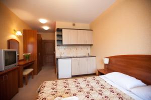 a hotel room with a bed and a television at Willa Gryf in Mielno