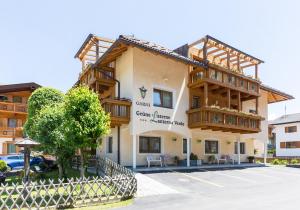 un edificio con balconi e una macchina parcheggiata in un parcheggio di B&B Grüne Laterne - Lanterna Verde a Sesto