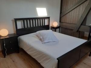サン・テミリオンにあるLes logis des Vignobles Saint Emilion en Duplex n 2 avec terrasseのベッドルーム(白い大型ベッド、ランプ2つ付)