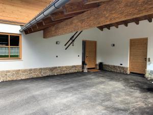an empty garage with a stone wall and wooden ceilings at Chalet Hoamatgfühl mit Gartensauna - in der Nähe von Schladming in Haus im Ennstal