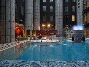 a large pool with a fountain in the middle of a building at Tallink Express Hotel in Tallinn