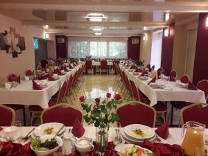 a banquet hall with white tables and red chairs at Hotel Atlantis in Poznań