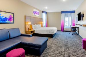 a hotel room with a bed and a couch at La Quinta by Wyndham San Antonio Alamo City in San Antonio