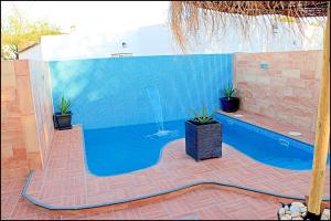 a swimming pool with a fountain in the middle at Chalet 2 dormitorios con piscina privada in Conil de la Frontera +17 photos