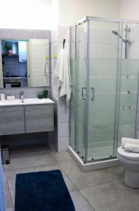 ein Bad mit einer Dusche, einem Waschbecken und einem WC in der Unterkunft Trinacria apartments in Catania