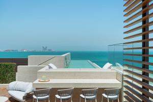 a patio with chairs and a swimming pool on a building at Jumeirah Al Naseem Dubai in Dubai