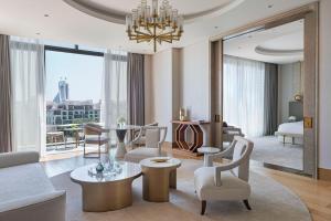 a living room with a chandelier and a living room with a couch at Jumeirah Al Naseem Dubai in Dubai