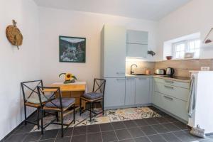 kuchnia ze stołem, krzesłami i lodówką w obiekcie Apartment Amula w Korčuli
