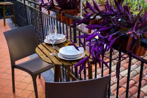 einen Tisch mit Tellern und Weingläsern auf dem Balkon in der Unterkunft Trinacria apartments in Catania
