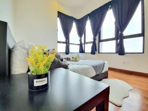 a bedroom with a bed and a table with flowers on it at I-City Shah Alam by BeeStay Management in Shah Alam