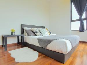 a bedroom with a bed with a table and a white rug at I-City Shah Alam by BeeStay Management in Shah Alam +89 photos