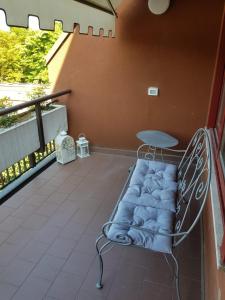 un banco en un balcón con mesa y silla en CIGNI HOUSE - da Anna&Ale, en Basiglio