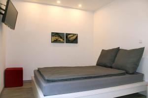 a bed in a room with two pictures on the wall at Cube-House Ferienhaus in Franken in Volkach