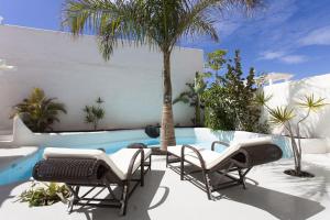 un patio con sillas y una piscina en Villa Alegria, en La Oliva