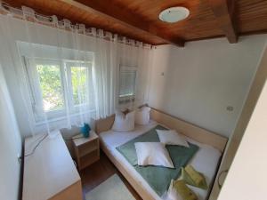 mały pokój z łóżkiem i oknem w obiekcie Apartman Lu w mieście Vir
