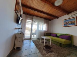salon z zieloną kanapą i stołem w obiekcie Apartman Lu w mieście Vir