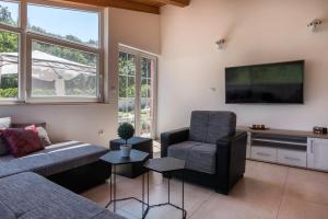 a living room with a couch and a chair and a television at House Bumbiste 1703 in Banjole