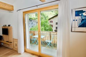 una porta scorrevole in vetro con vista su un balcone di Terra Berni a Vals
