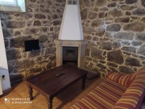 a living room with a table and a fireplace at Pensión - Albergue de Logrosa in Negreira