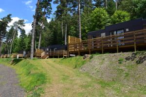una casa al lado de una colina con árboles en Camping Domaine du Lac Chambon en Murol