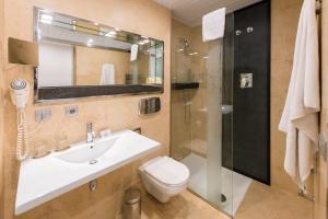 a bathroom with a sink and a toilet and a shower at Hotel Fruela in Oviedo