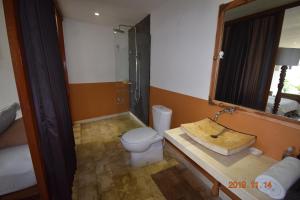 y baño con aseo, lavabo y espejo. en Villa Lotus 8, en Canggu