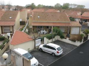 a white car parked in a parking lot in front of a house at Vias Plage - Maison de vacances in Vias