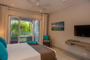 蒙舒瓦西的住宿－蒙舒瓦西海灘度假公寓式酒店，一间卧室设有一张床、一台电视和一个窗口。