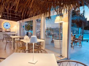 un ristorante con tavoli e sedie e una grande finestra di Viestemare Resort & SPA a Vieste
