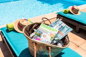 a basket with a magazine next to a swimming pool at La Beytina - B&B and Apartment in Pennautier