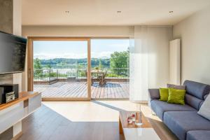 a living room with a couch and a view of a deck at Lebensart am See in Bad Endorf
