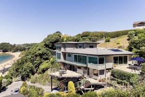 uma casa grande numa colina junto a uma praia em Kaiteriteri Retreat em Kaiteriteri