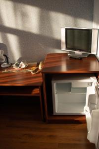 a desk with a microwave and a television on it at Skazka Inn in Yaroslavl