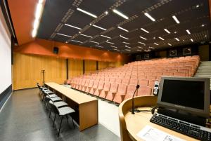 an auditorium with chairs and a computer on a desk at Hotel Kerpely in Dunaújváros