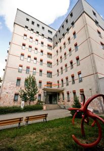 un edificio con una escultura roja delante de él en Hotel Kerpely, en Dunaújváros