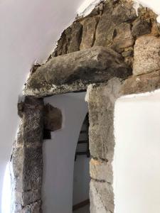 un arco de piedra en un edificio con una pared de piedra en 1722 Chambres de Charmes, en Ville-di-Paraso