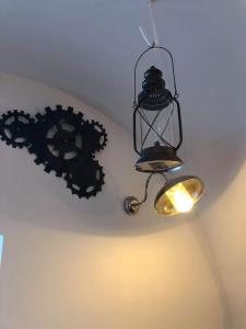 a black chandelier hanging from a ceiling with gears at 1722 Chambres de Charmes in Ville-di-Paraso