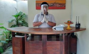 un hombre con las manos delante de una mesa con un teléfono en Imani Villas, en Canggu